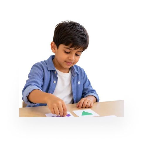 Young learner arranging shape cards on a worksheet
