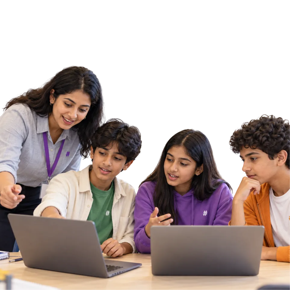 Teacher working with a group of students at laptops